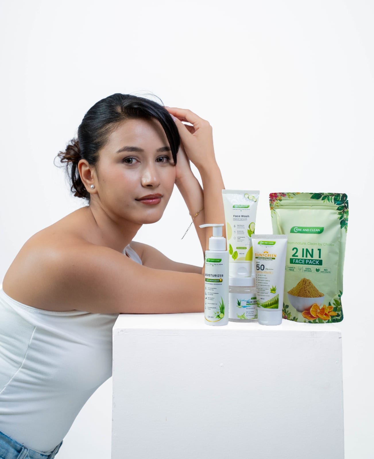 Model beside the complete Care and Clean Nepal skincare range on a white pedestal